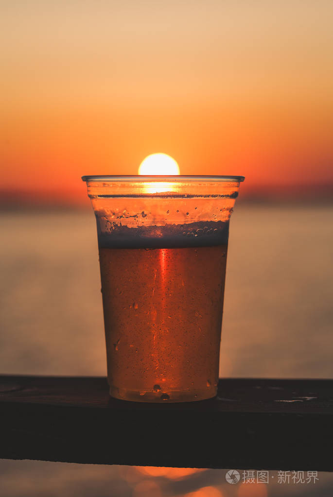 喝一杯啤酒杯子与夕阳