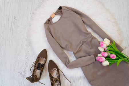 灰色麂皮绒的衣服 棕色的鞋和一束郁金香。时尚概念