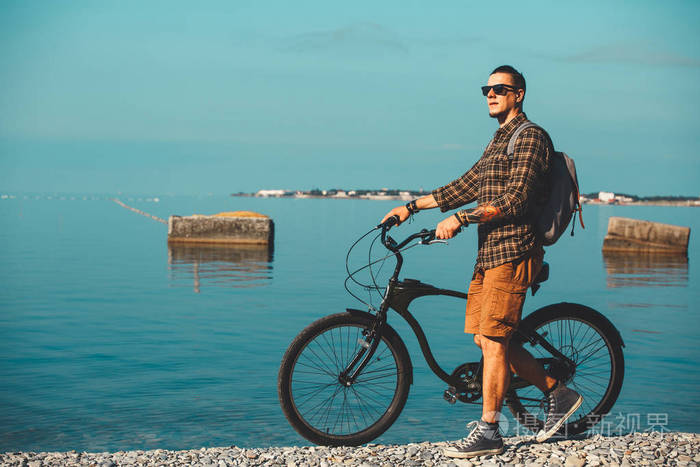 年轻男性骑自行车的人与自行车上海岸散步享受着大海的景色假日旅游