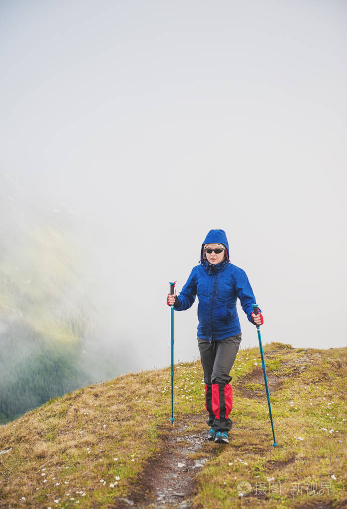 走在雾山顶的女人徒步旅行者