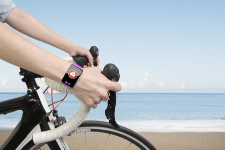 骑自行车的女子手戴健康传感器智能手表