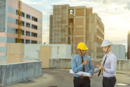 微笑年轻建筑师或工程安全帽与生成器