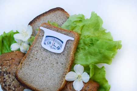 虚秤由孤立的白色背景上的面包切片。饮食概念，促进健康的饮食和体重管理