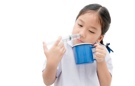 亚洲学生女孩冲洗她的鼻子与注射器和生理盐水 iso