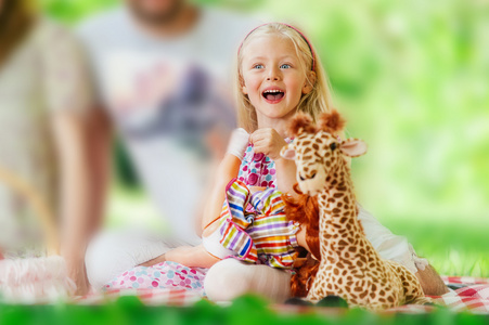 夏天一天与她最喜欢的玩具在草地上的可爱小女孩 portret
