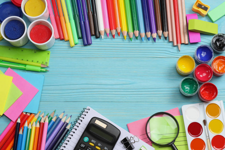 学校和办公用品。学校背景。彩色的铅笔 钢笔 痛 学校和学生的教育，在蓝色木背景用纸。顶视图