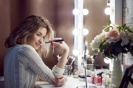 美丽的女孩,在化妆品的桌子旁边的肖像照片