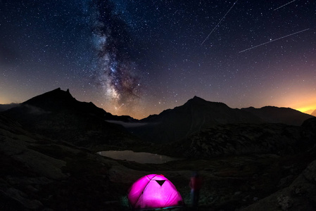 与在星空下阿尔卑斯山和银河系高空照明帐篷露营反映在湖上。冒险和探索在夏天