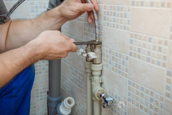 帅气的水管工人更换厨房水龙头