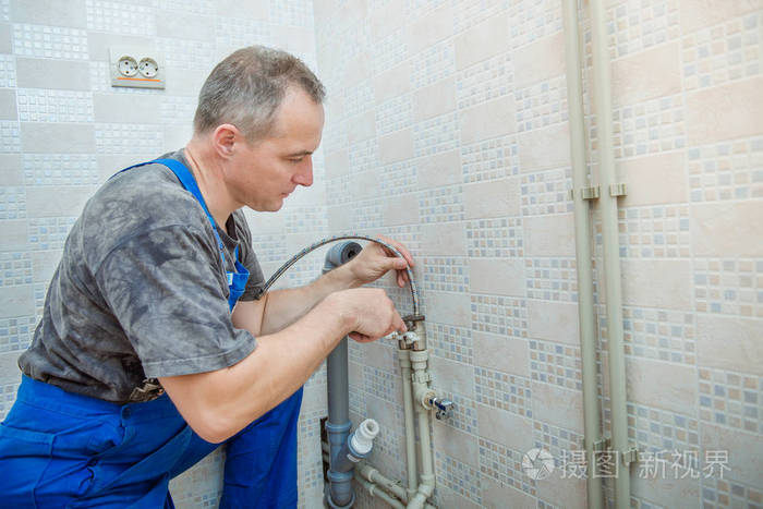 帅气的水管工人更换厨房水龙头