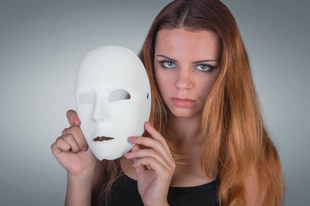 年轻的情感女人坚持工作室手姿势的面具