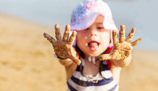 显示她的手用沙子的小女孩