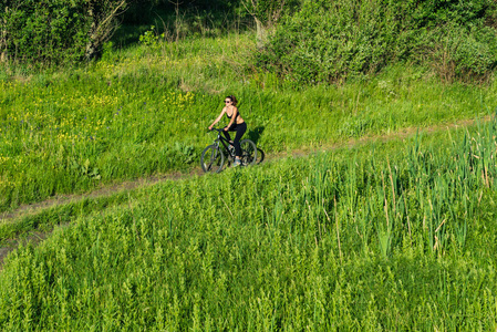 骑山地自行车在该字段中的女孩