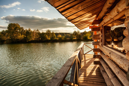 木房子的阳台上水在湖，在日落时