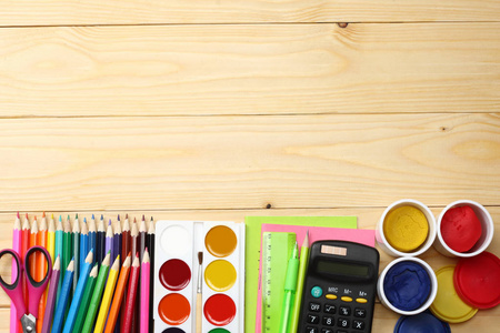 学校和办公用品。学校背景。彩色的铅笔 钢笔 痛 学校和学生的教育，对木制背景用纸。顶视图