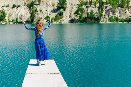 年轻女孩的湖岸上的蓝色礼服