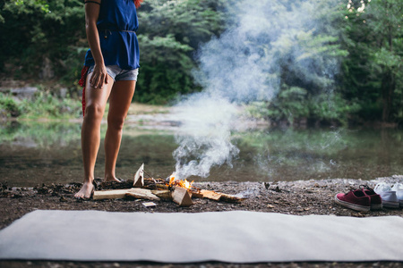 赤脚站在篝火旁边的女人图片