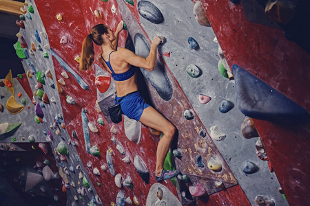 职业女性登山运动员抱石墙上