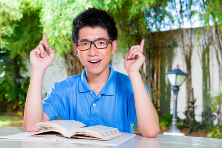 年轻的中国男孩与学校的家庭作业