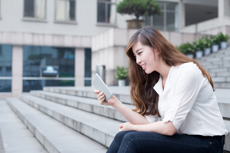 亚洲女学生在校园中使用平板电脑