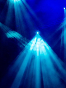 蓝色光线透过烟雾在剧院或音乐会大厅聚光灯。照明设备演出或表演