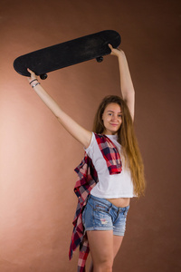 一个女孩与一个滑板在工作室里的肖像