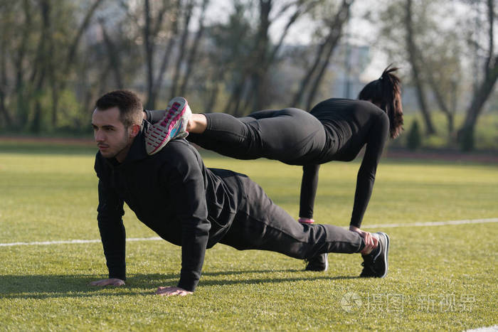 体育对夫妇在公园里做俯卧撑