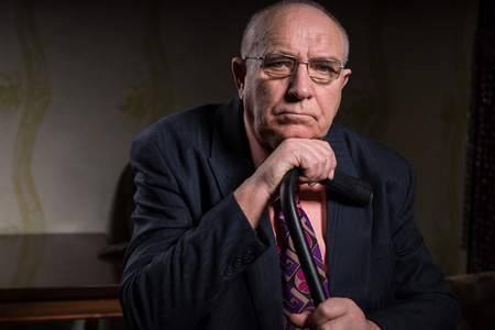 的拐杖站立的一个高级男子的全长肖像一位老人拄着拐杖行走在一套西装