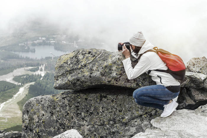女摄影师拍照在山的顶峰