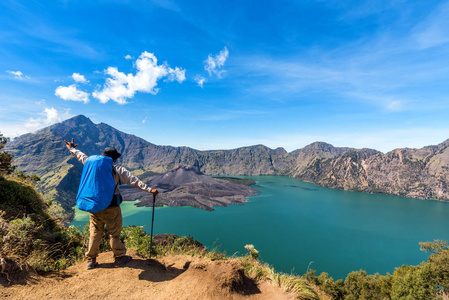 传播的手，背包徒步旅行者人享受和满意活火山巴鲁杰瑞，湖塞格拉衲和首脑会议的瑞嘉尼山景后完成攀登瑞嘉尼山