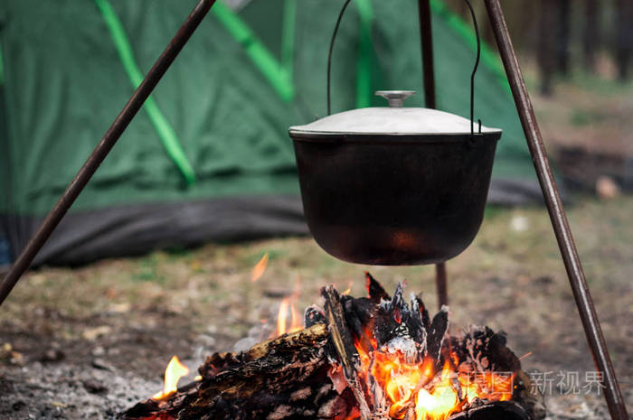 徒步旅行在篝火的锅在山里有帐篷旅行