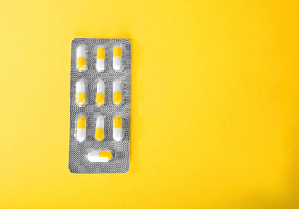 药物治疗明亮而有光泽的黄色背景的特写图标。白色和橙色药片，药品，吸塑片。Prescripted 的药品