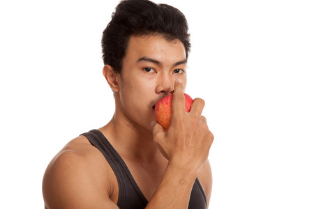 肌肉发达的亚洲男子咬红红的苹果