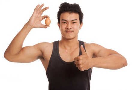 肌肉发达的亚洲人竖起大拇指与鸡蛋