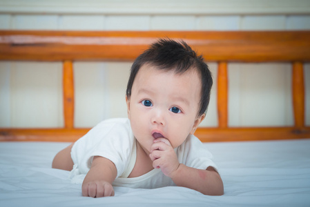 可爱的新生婴儿女孩在床上的肖像