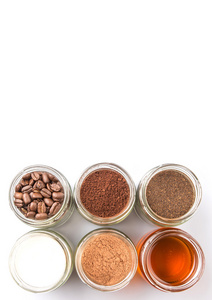 咖啡豆 咖啡粉 奶精 可可粉 蜂蜜制成的茶叶叶片在梅森罐子里超过白色背景