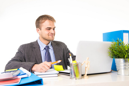 年轻有吸引力的商人微笑看满意的办公室伏案工作忙着手提电脑照片