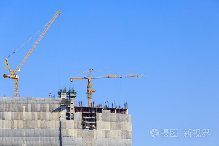 建筑塔吊和施工工地在蓝蓝的天空下