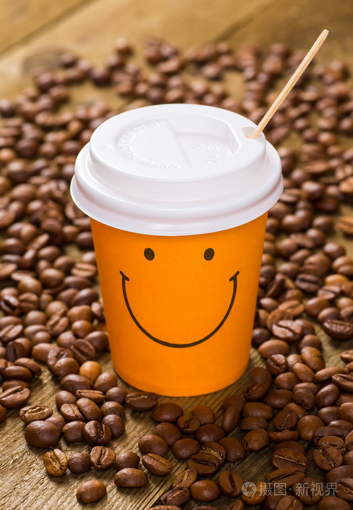 纸杯装的咖啡拿铁咖啡和咖啡豆木制的桌子上