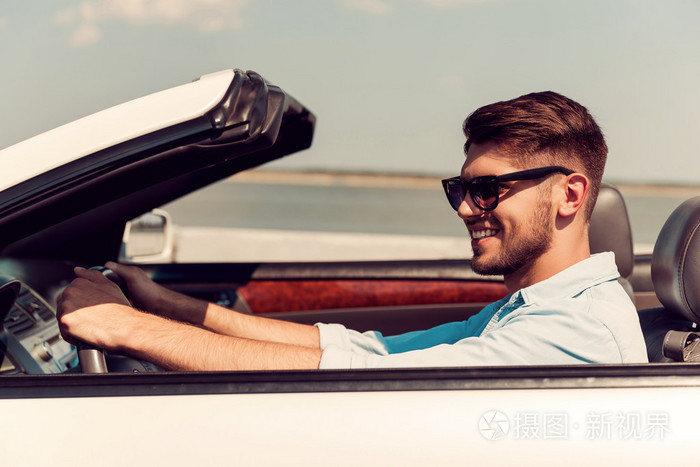 年轻男子驾驶他白色的敞篷车