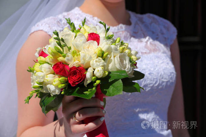 新娘在婚礼上抱着五颜六色的鲜花花束用她的双手