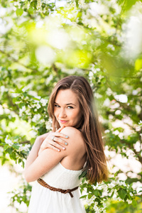 美丽的年轻女子，在春天的花园，在苹果树上的花，软焦点