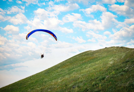 用降落伞映衬在蓝天下的三轮车。滑翔伞飞行