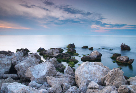 多姿多彩的夏天海景。在日落时的岩石海岸