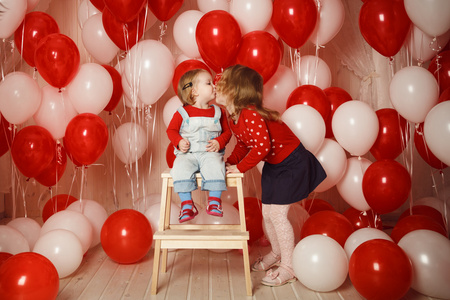 姐妹陪伴气球两个小姐妹亲吻着红色和白色的气球照片