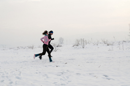 男人和女人在雪地上奔跑