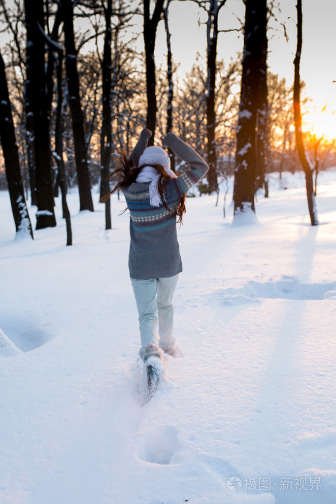 年轻漂亮的女人 (女孩) 玩雪在暖和的衣服微笑在公园里