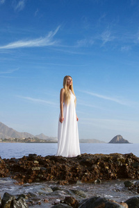海滩和夫人穿白色连衣裙的壮观景色