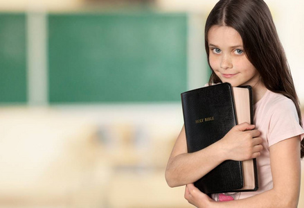 小女孩抱着圣经 