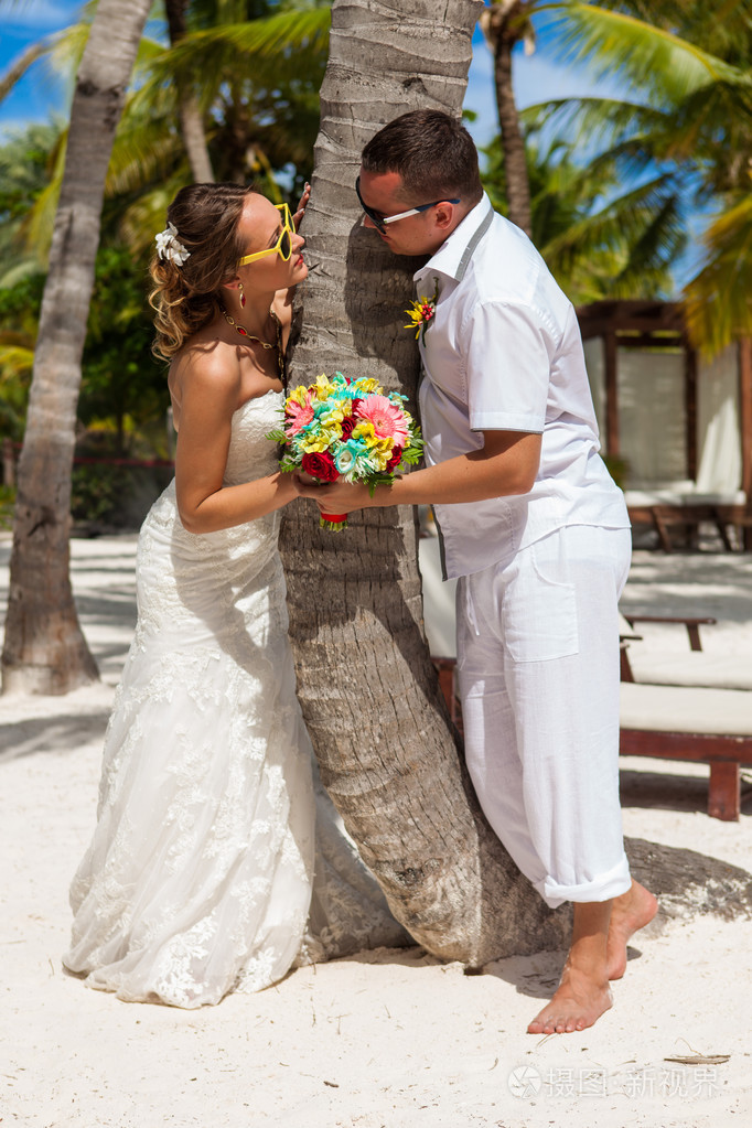 年轻夫妇在棕榈树的背景